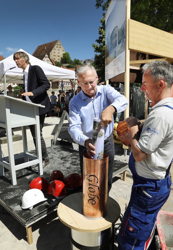 Architekt Dieter Koch befüllt die "Zeitkapsel" mit den Plänen des Neuen Globe.