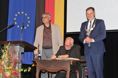 Flankiert von Arne Braun und OB Richard Arnold trägt sich José F. A. Oliver in das Goldene Buch der Stadt ein.